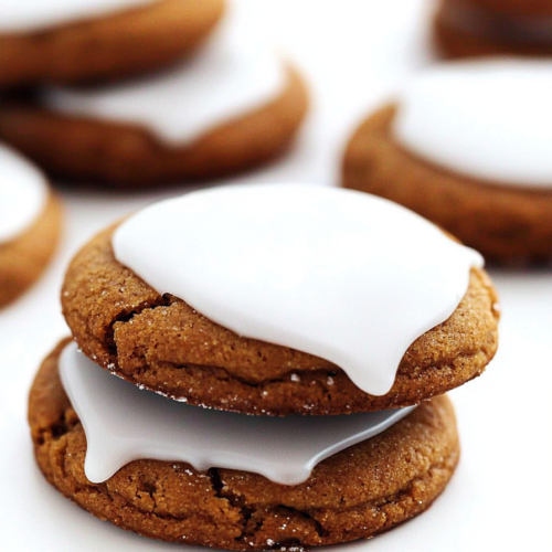 Freshly baked spiced treats with a bright glaze finish and subtle cracks on top.