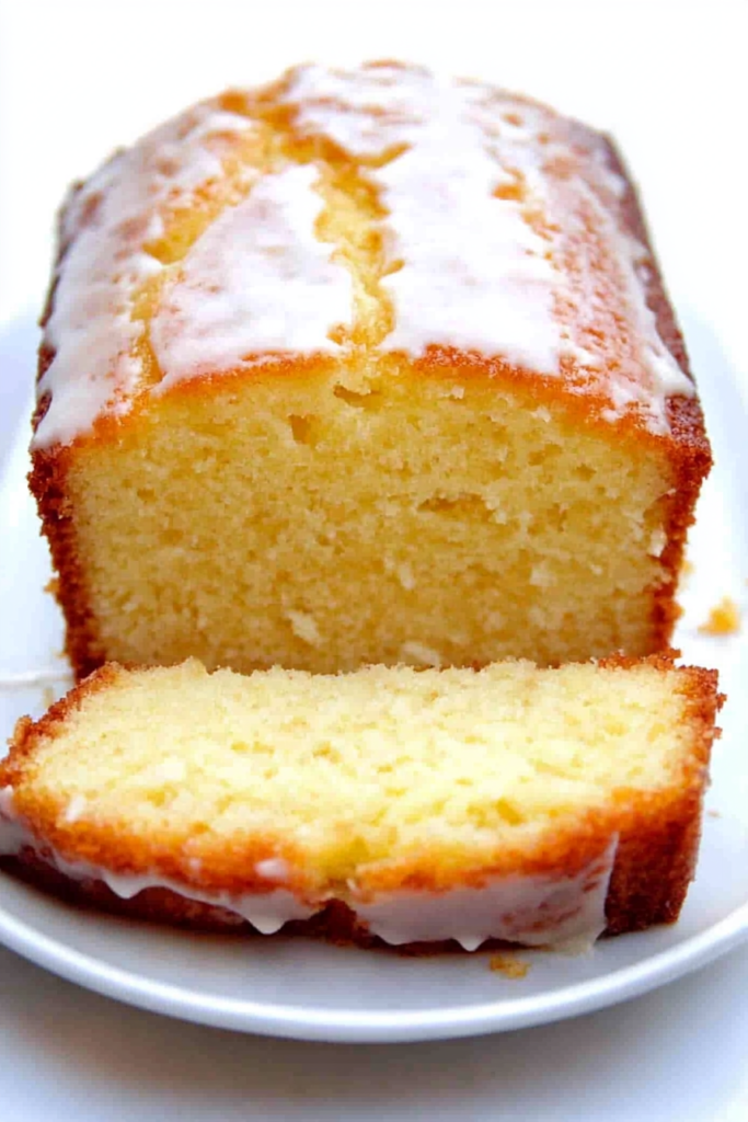 Moist homemade loaf cake with a sweet glaze dripping over the top