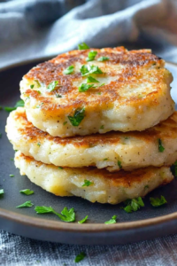 Homemade potato patties with browned surfaces and flecks of fresh parsley