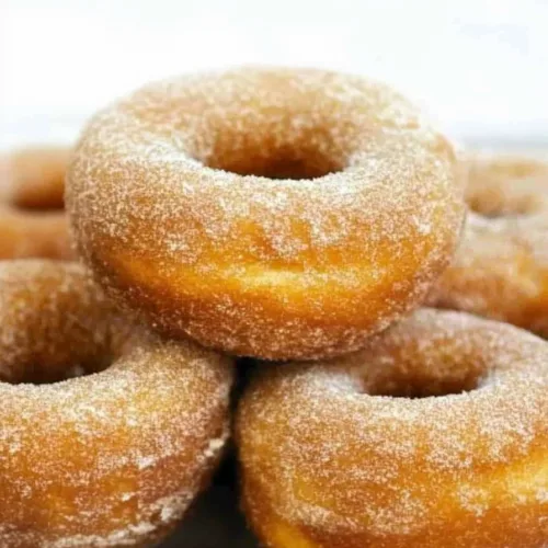 Soft homemade doughnuts coated in powdered sugar