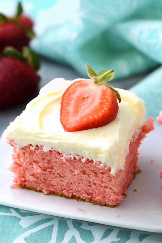 Homemade sheet cake with creamy topping and juicy strawberry accent.