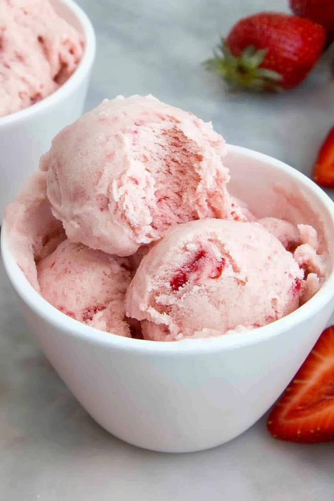 Refreshing strawberry ice cream scoops with vibrant color and creamy consistency.