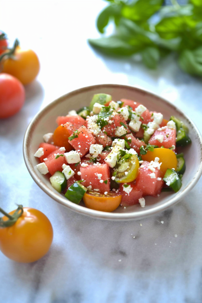 Colorful summer salad with juicy watermelon cubes, cherry tomatoes, and cucumber slices