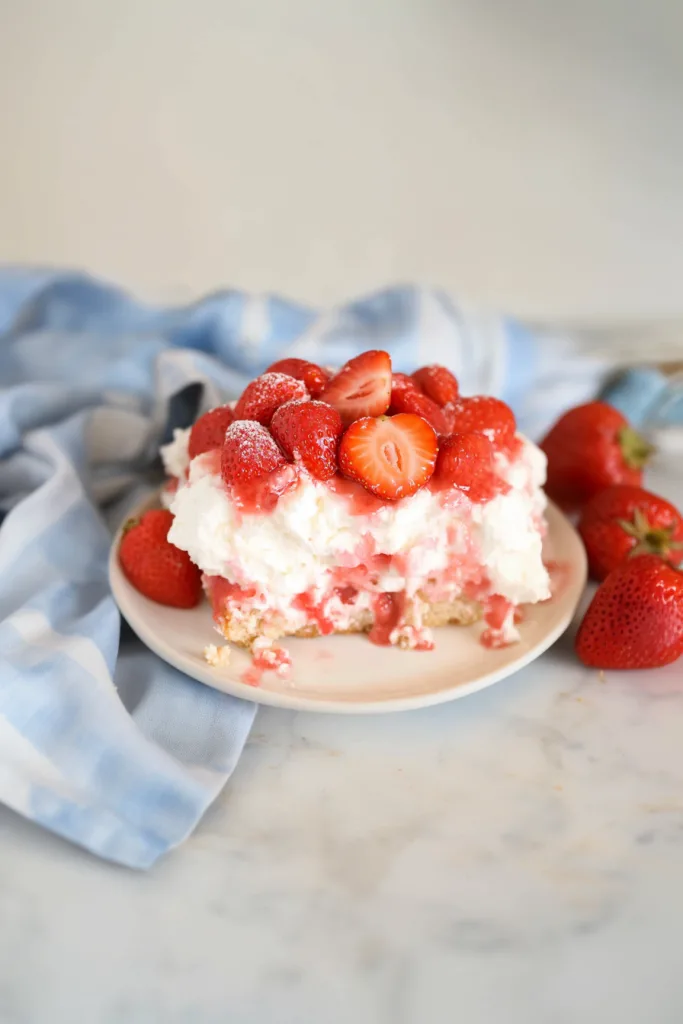 Slice of angel food cake topped with whipped cream and fresh strawberry glaze ๐