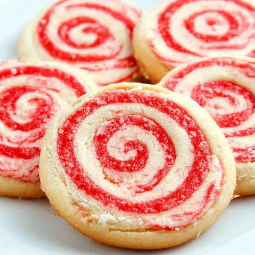 Candy cane pinwheel cookies stacked on a plate, highlighting their vibrant spiral pattern.