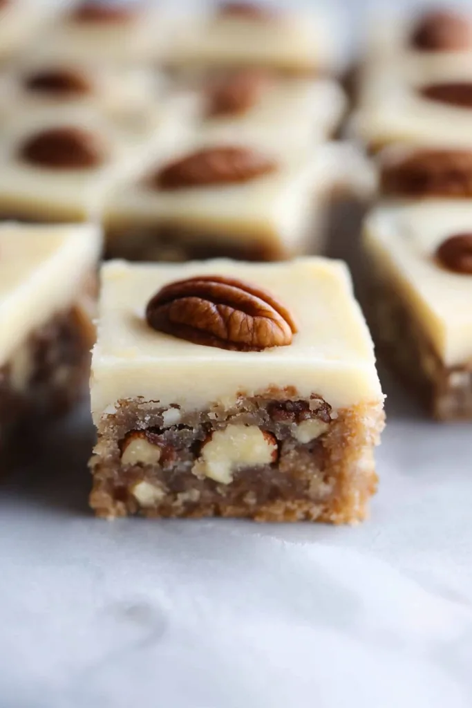 Moist dessert squares topped with glossy icing and crunchy pecans.