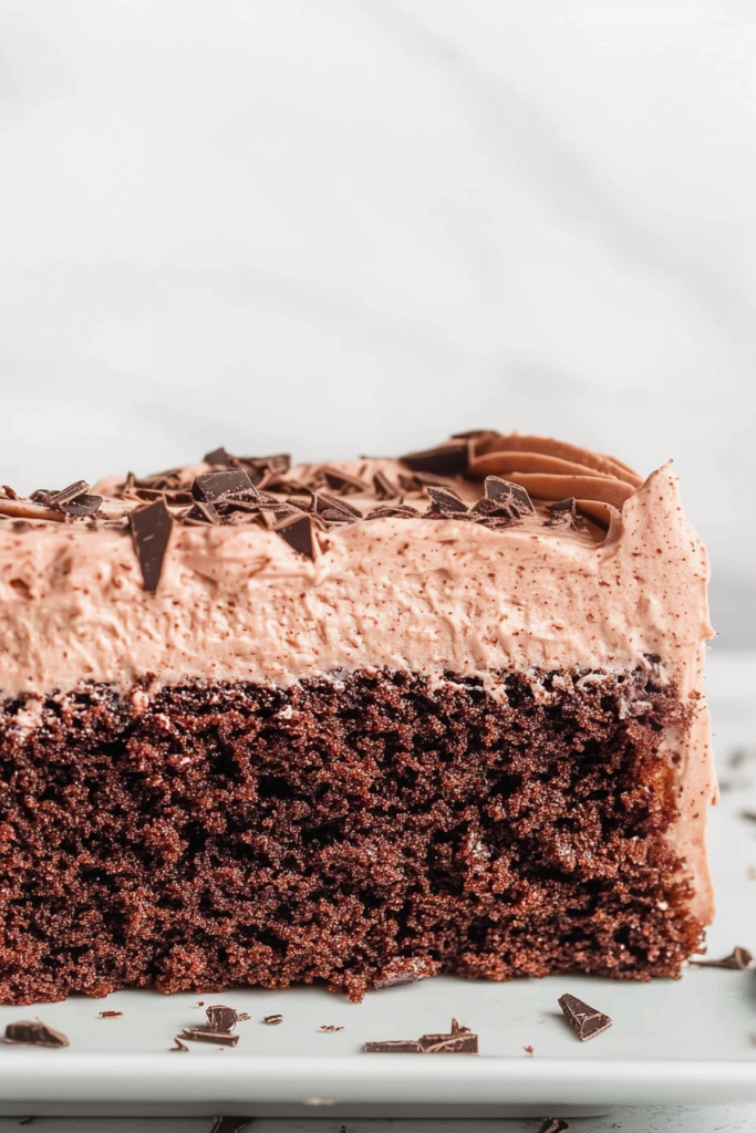 Elegant dessert presentation showing a single cake slice decorated with chocolate curls.