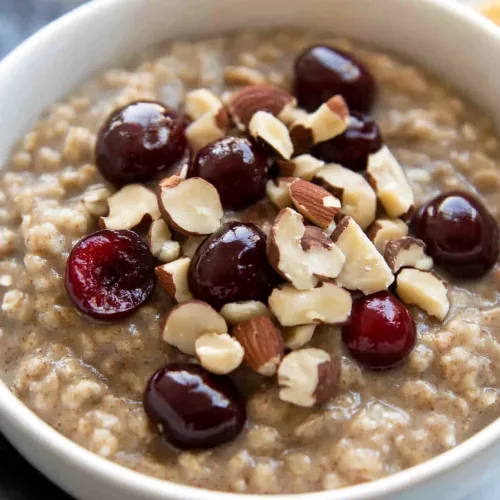 Comforting breakfast dish with creamy oats, fresh cherries, and nutty crunch.