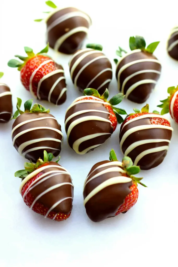 Fresh strawberries dipped in glossy milk chocolate with delicate white chocolate drizzle.