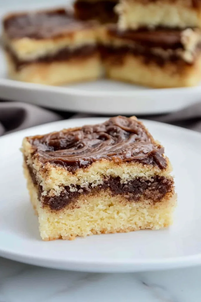 Dessert squares arranged together, emphasizing glossy finish and soft interior layers.