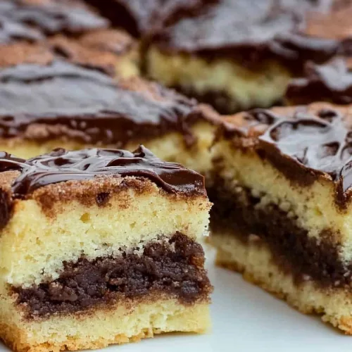 Batch of neatly cut cake pieces with smooth chocolate surface and visible layered texture.