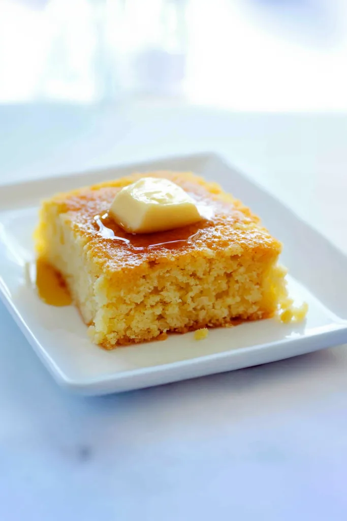 Overhead view of cornbread served simply with butter glistening across the surface.