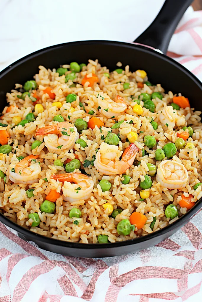 Close-up of homemade shrimp and vegetable rice garnished with fresh herbs