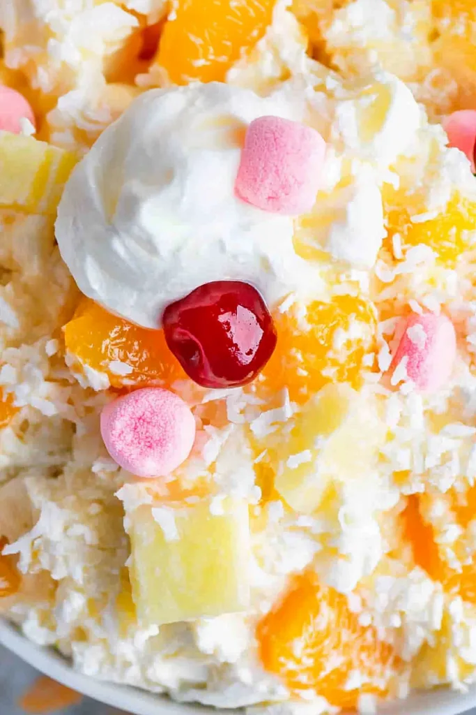 Closeโup of a fluffy dessert bowl filled with marshmallows, pineapple, and mandarin oranges.