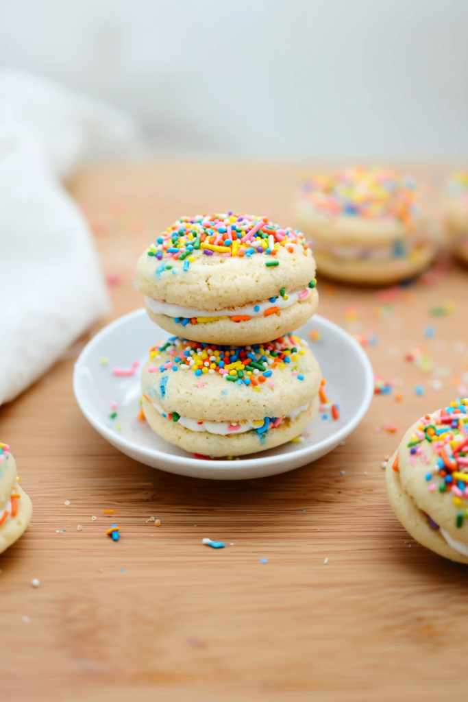 Festive cookies filled with white cream, topped with bright sprinkles.