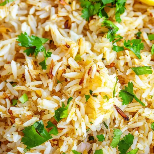 Fluffy rice with fresh herbs sprinkled on top, served in a simple bowl.