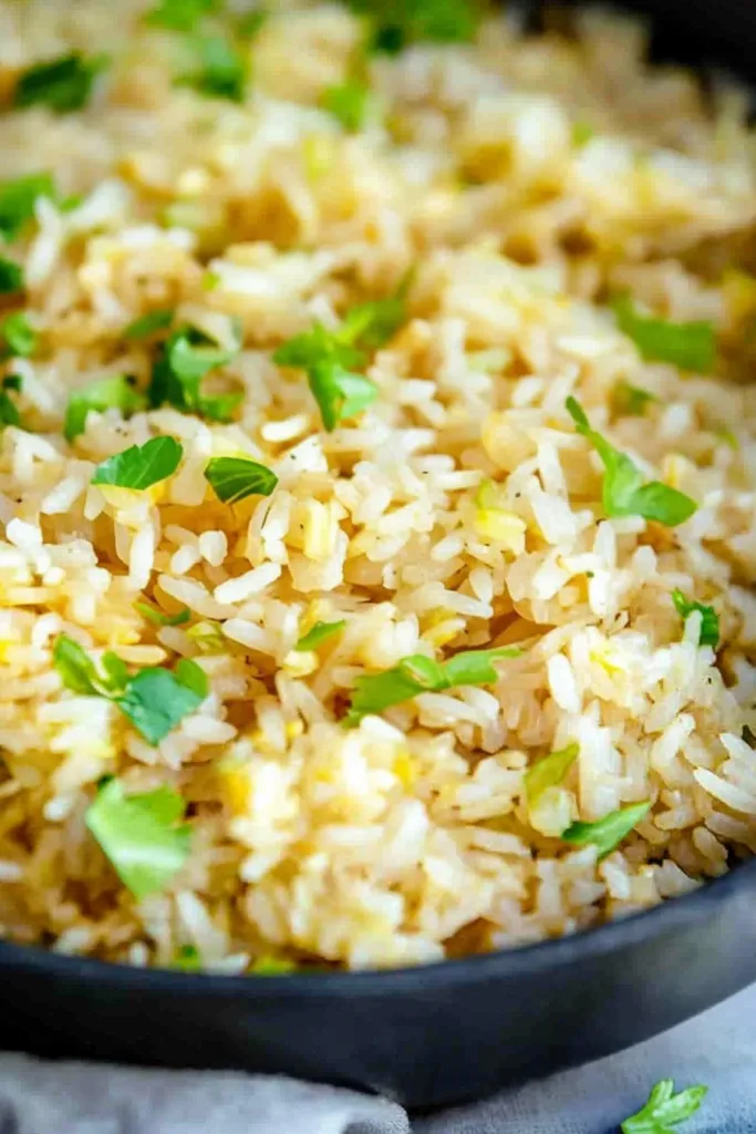 Rustic rice dish with herbs, styled in a dark bowl for contrast.