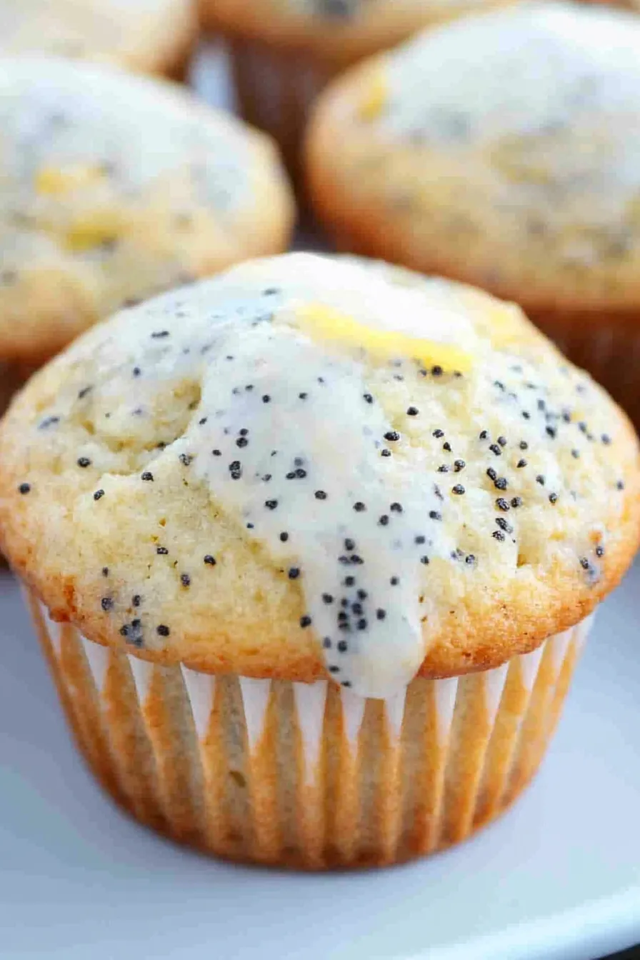 Close-up of a muffin topped with a thin lemon slice, showing its moist texture.