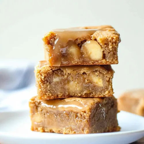 Stacked dessert bars highlighting the contrast between the shiny maple topping and soft apple-filled interior.
