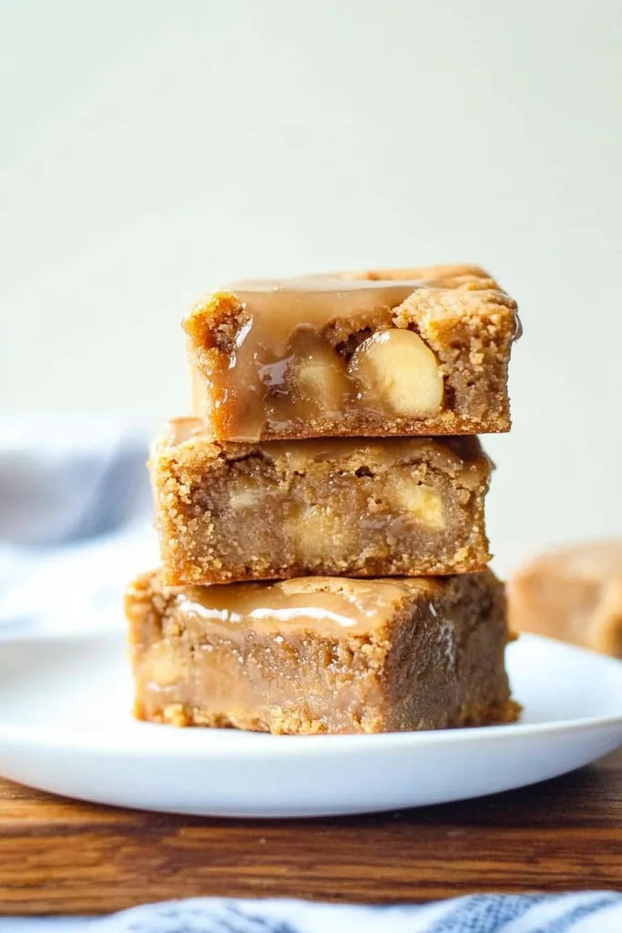 Stacked dessert bars highlighting the contrast between the shiny maple topping and soft apple-filled interior.