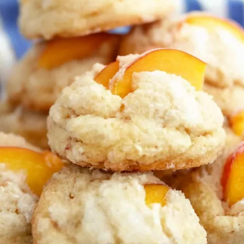 Close-up of crumbly shortcake cookies topped with juicy peach pieces.