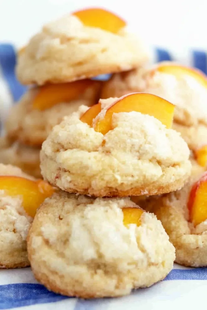 Close-up of crumbly shortcake cookies topped with juicy peach pieces.