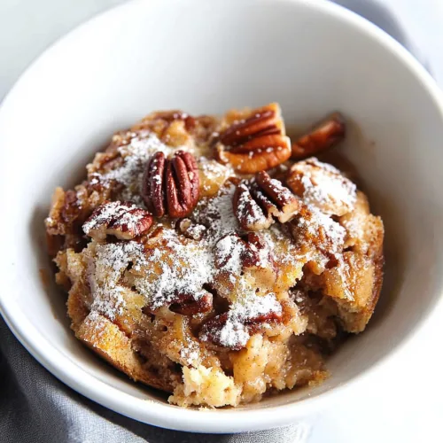 Warm and gooey bread pudding with cinnamon filling and crunchy pecans on top.