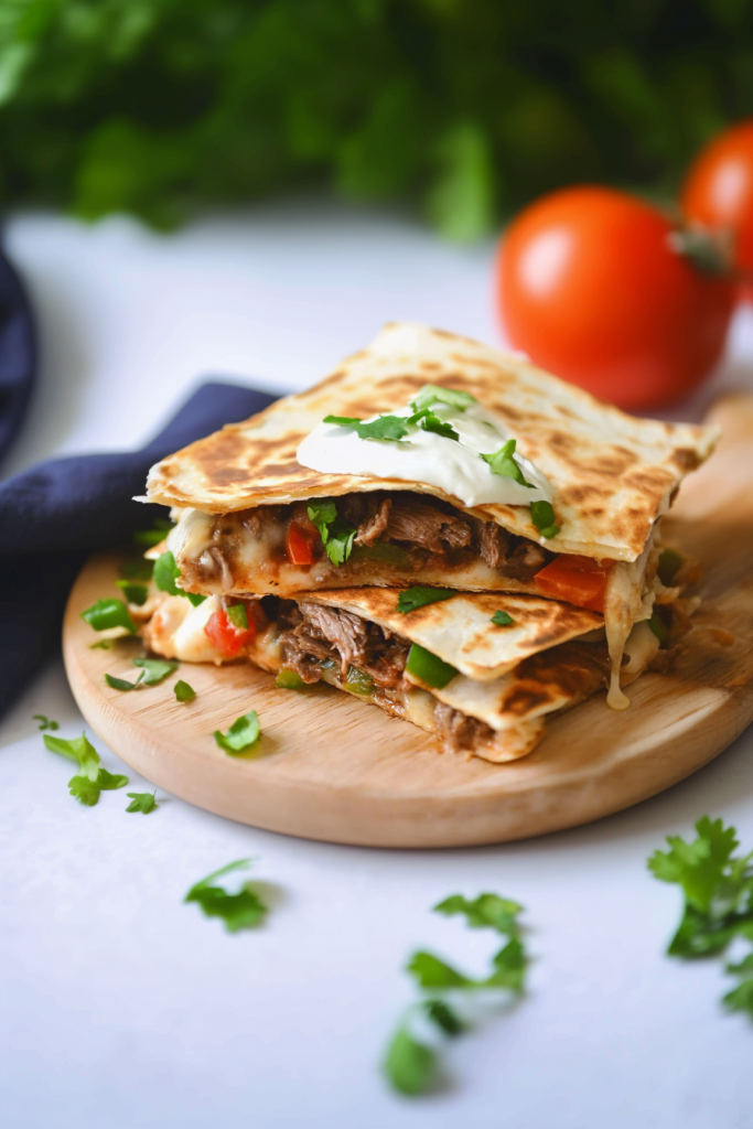 Final serving shot showing quesadilla halves topped with fresh cilantro and a dollop of cream.