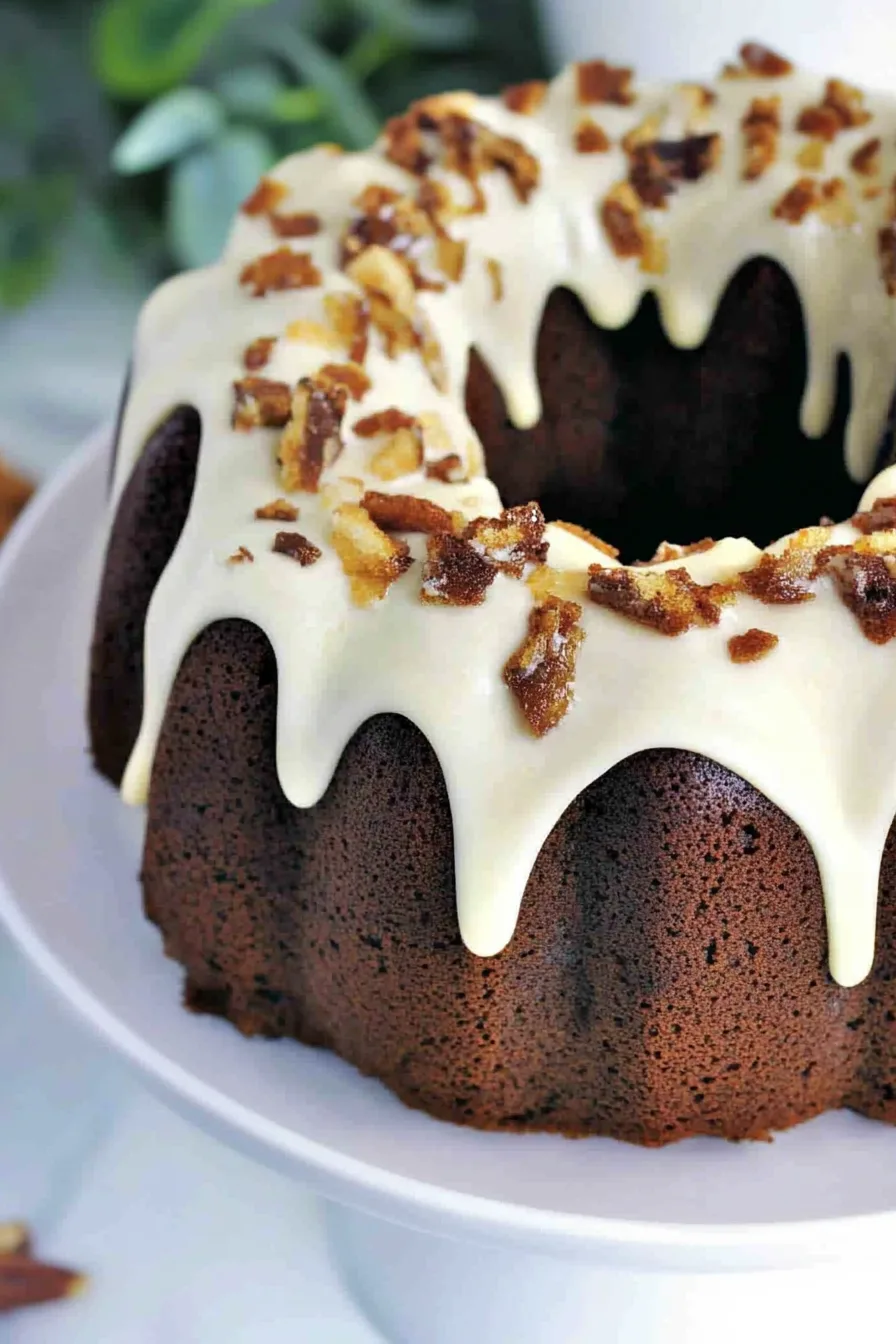Elegant bundt cake centerpiece with smooth icing and nutty topping, perfect for fall gatherings.