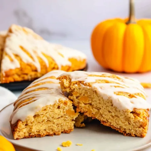 Freshly baked triangular scones with a creamy drizzle, highlighting their flaky texture.