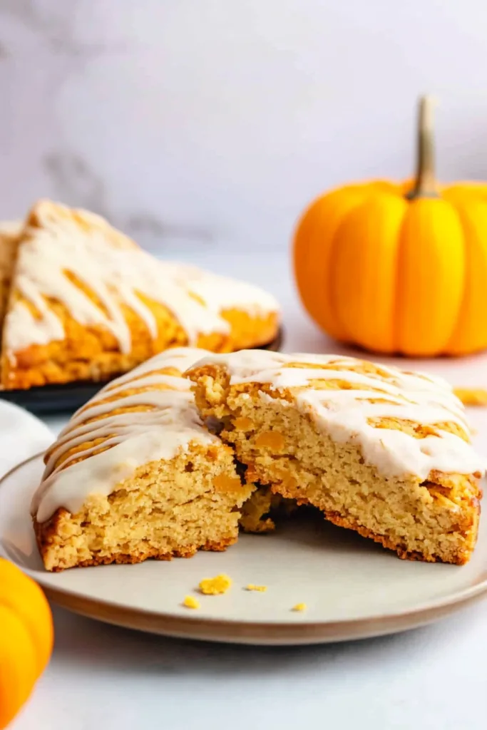Freshly baked triangular scones with a creamy drizzle, highlighting their flaky texture.