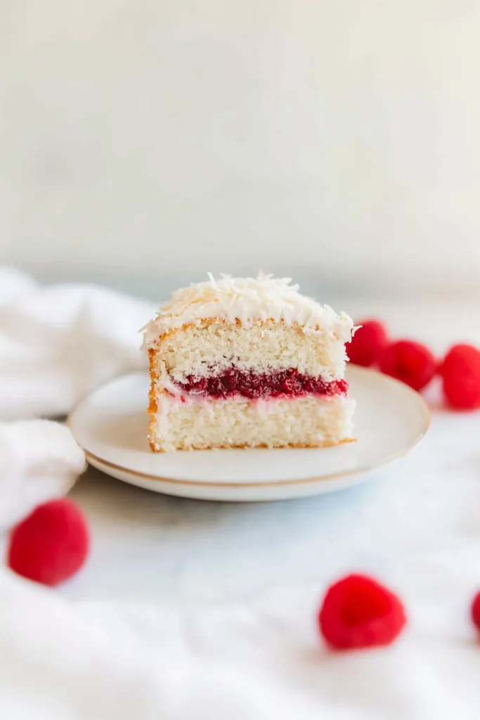 Decadent dessert cake with smooth frosting, berry layers, and coconut topping.