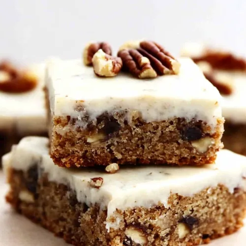 Dessert squares arranged neatly, highlighting frosting and nut topping.