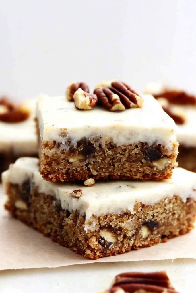 Dessert squares arranged neatly, highlighting frosting and nut topping.