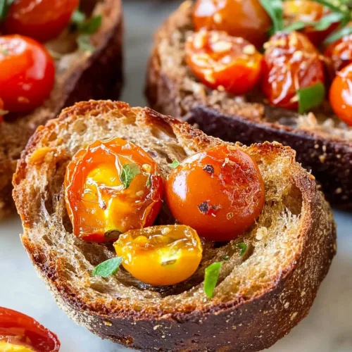 Golden slices of crusty bread layered with roasted tomatoes and a drizzle of olive oil.