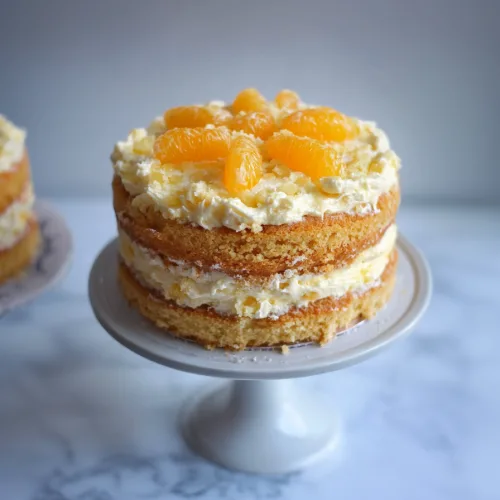 Soft frosted celebration cake dusted with powdered sugar and citrus segments