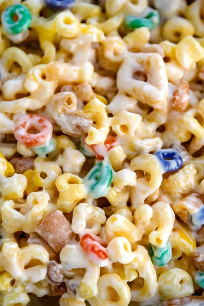 Homemade dessert snack mix featuring cereal squares, pretzels, and chocolate candies