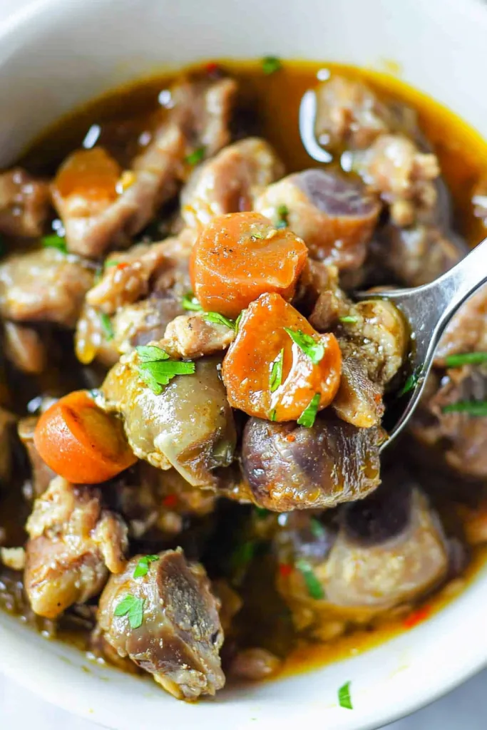 Close-up of hearty braised dish highlighting browned meat and herbs.