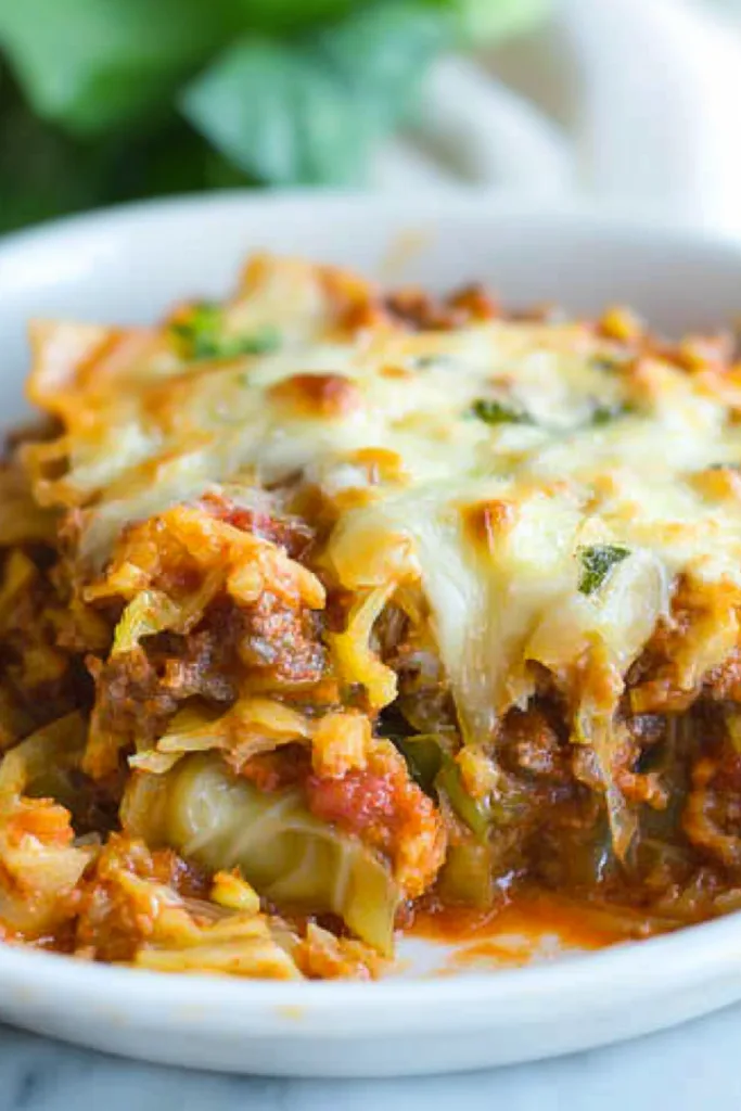 Layered serving of lasagna-style casserole with melted cheese and tomato sauce