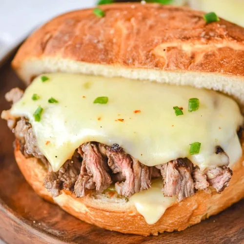 Toasted sandwich bun filled with shredded beef and topped with creamy melted cheese.