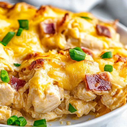 White plate of baked chicken dish with fresh garnish on top