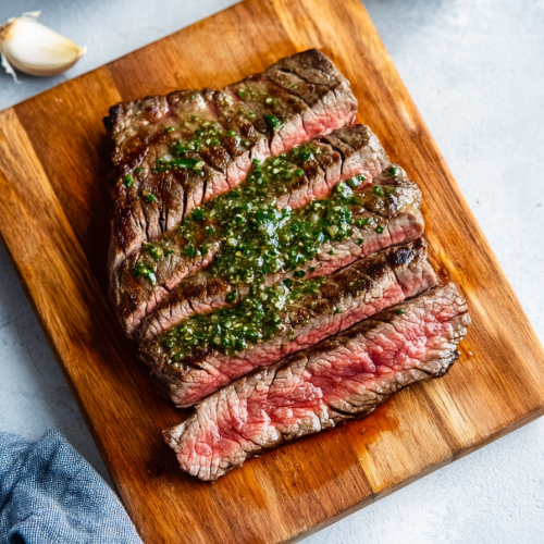 Tender steak slices displayed on a rustic board, highlighting the contrast between browned crust and rosy interior.