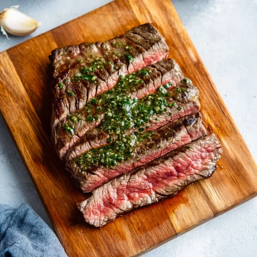 Tender steak slices displayed on a rustic board, highlighting the contrast between browned crust and rosy interior.