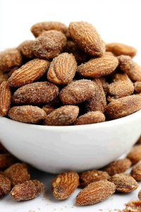 Snack bowl of glossy almonds styled simply for a clean presentation.