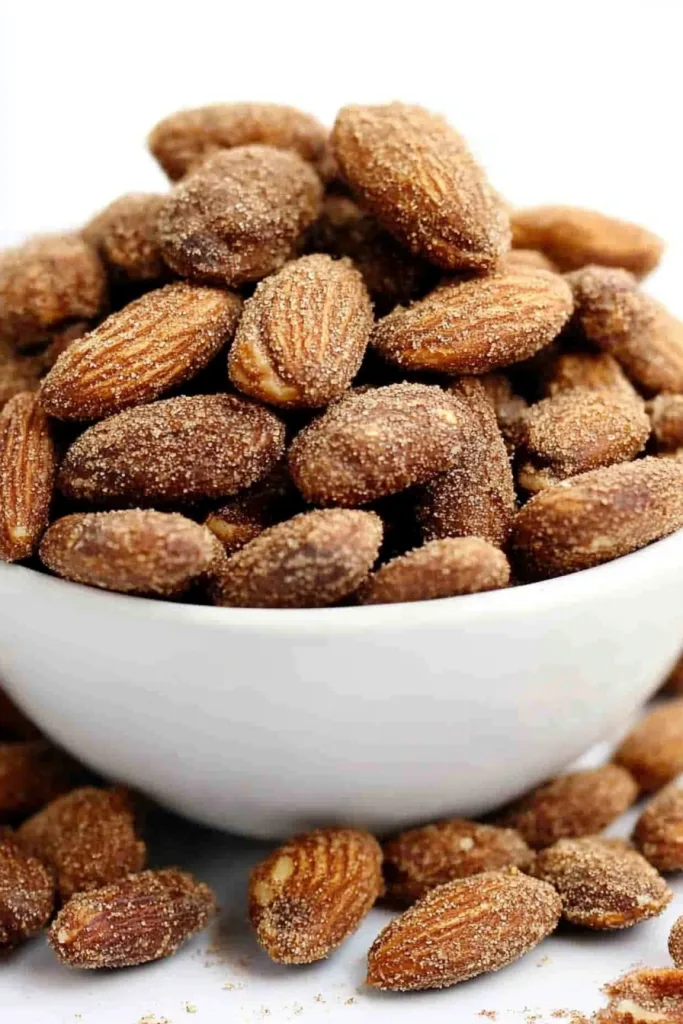 Snack bowl of glossy almonds styled simply for a clean presentation.