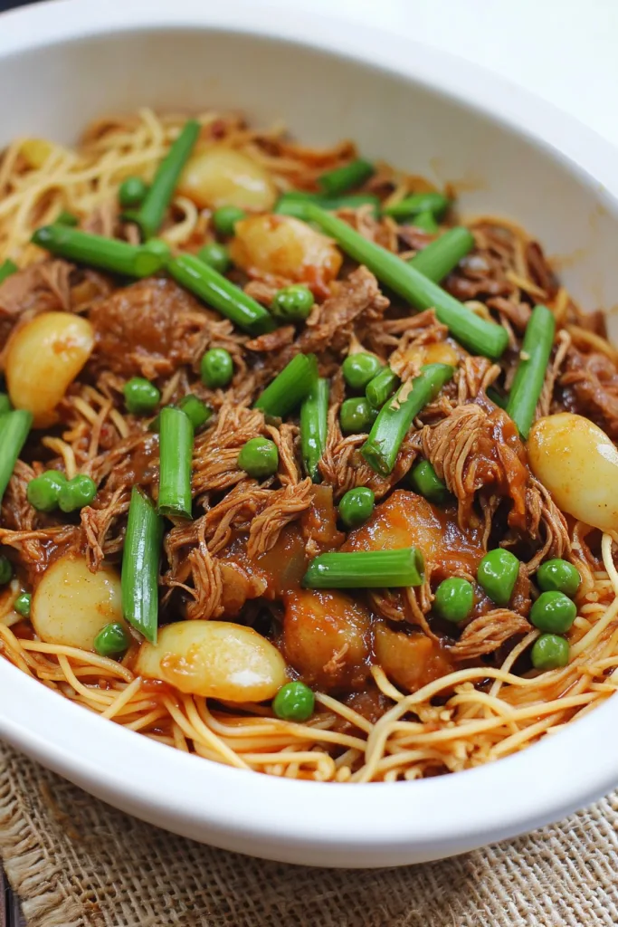 Colorful noodle dish with peas, onions, and leafy greens