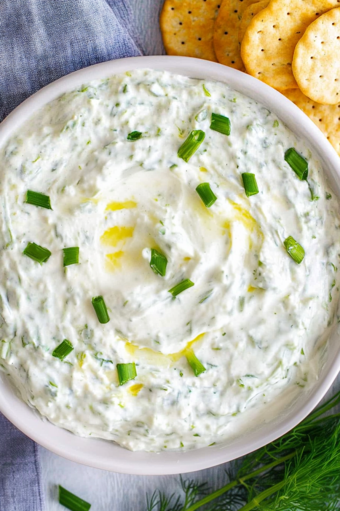 Close-up of creamy dip highlighting fresh herbs and glossy texture.