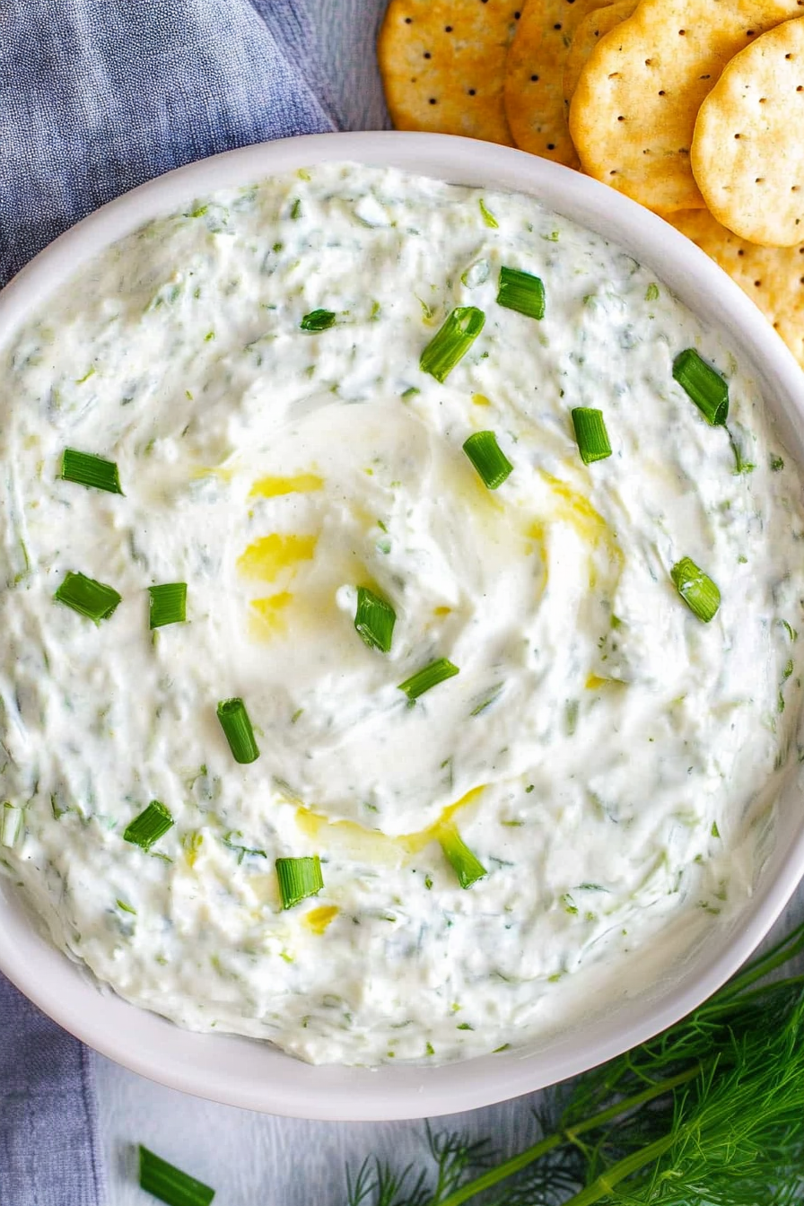 Close-up of creamy dip highlighting fresh herbs and glossy texture.
