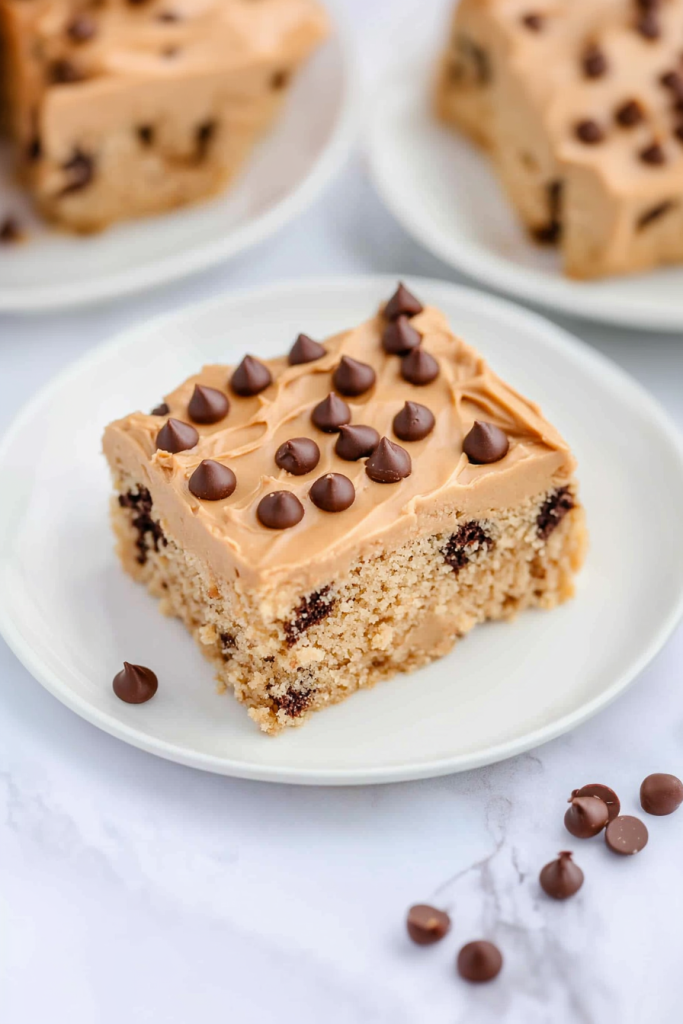 Square dessert bar topped with creamy peanut butter frosting and scattered chocolate chips.