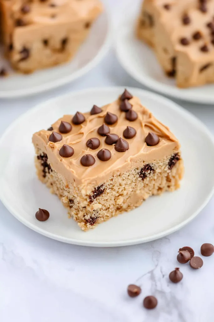 Square dessert bar topped with creamy peanut butter frosting and scattered chocolate chips.